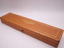 Closed brown Longines watch presentation box with gold Longines lettering and a gold decorative border.