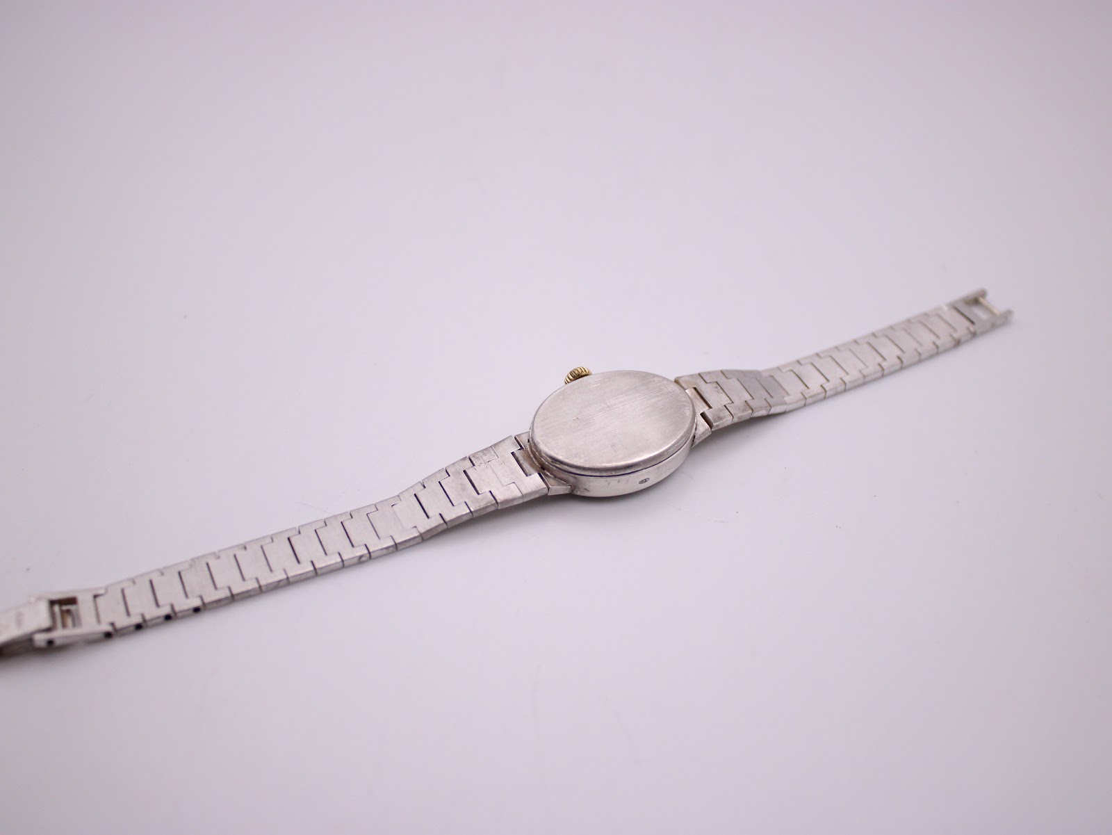 Rear view of the Longines watch, showing the plain silver case back and the consistent textured pattern of the bracelet.