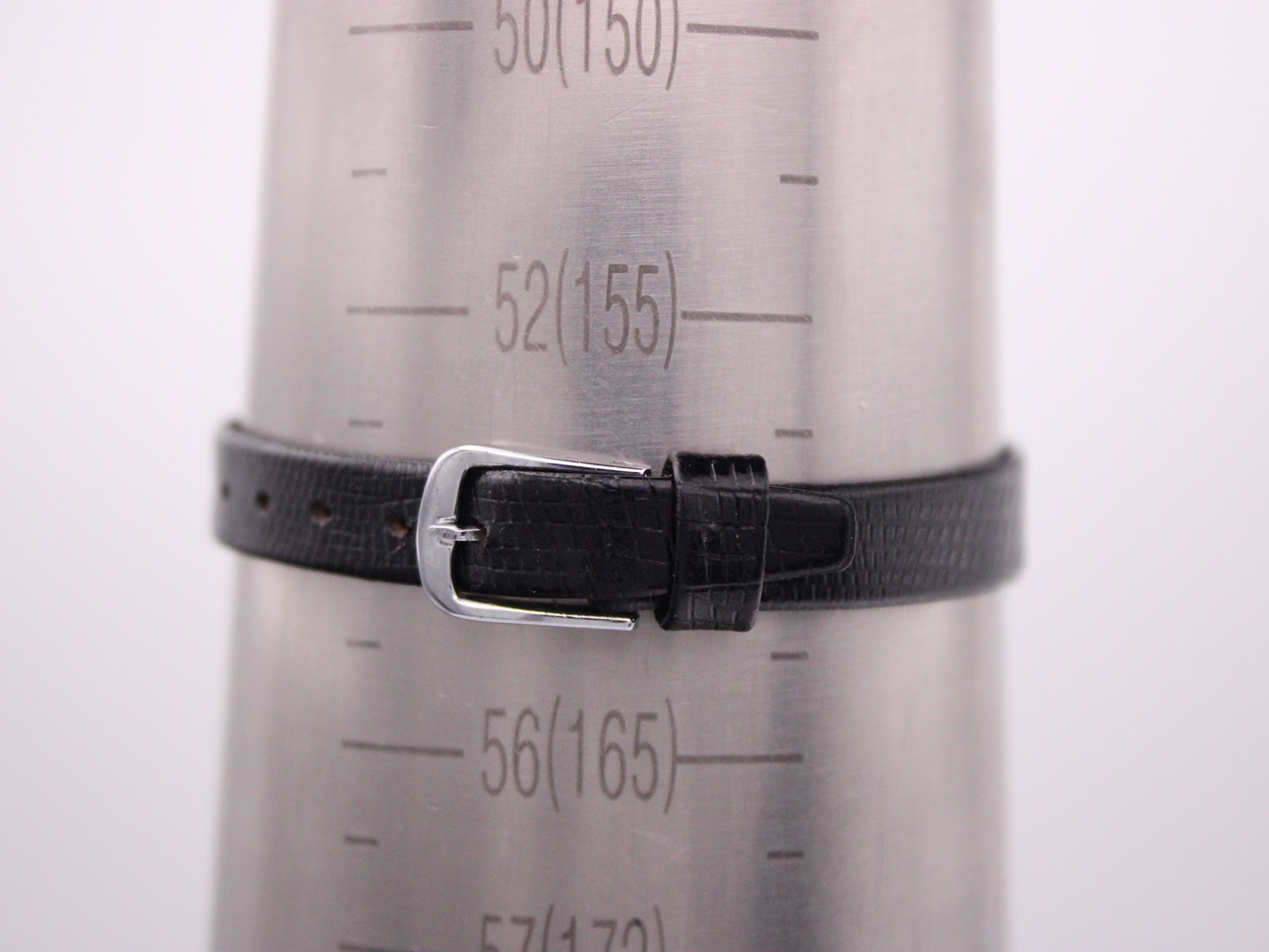 Black leather strap of the Longines watch on a wrist sizing gauge, showing an approximate wrist circumference measurement.