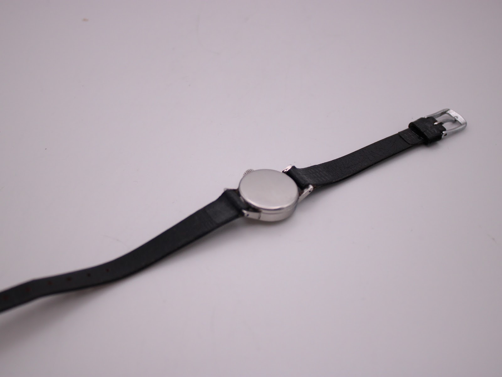 Full overhead view of the Longines 7271 watch from the back, showing the polished case back and black leather strap with buckle.