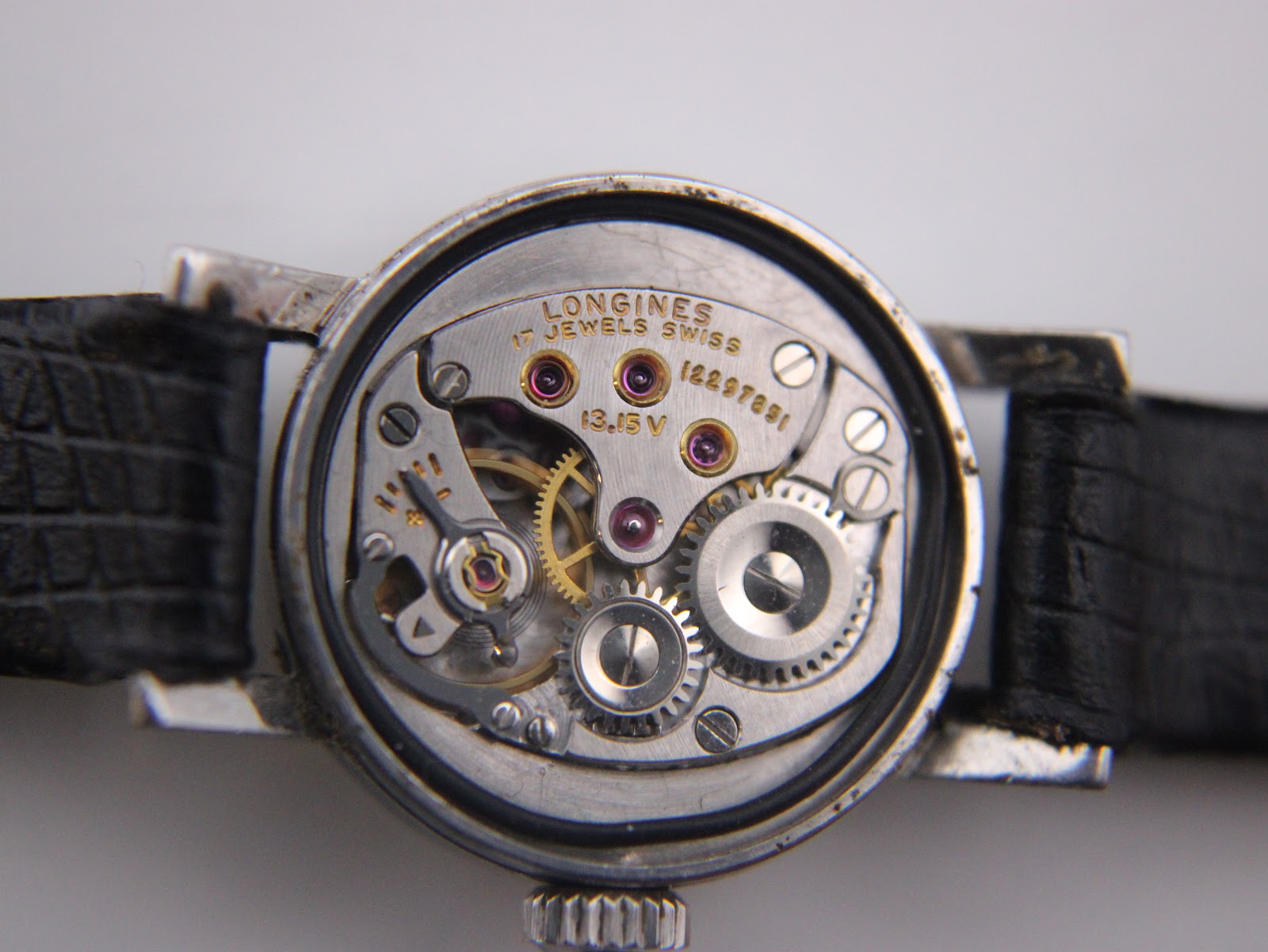 Close-up of the Longines 17 jewels manual wind movement, showing gears, rubies, and serial number 12297881.