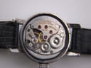 Extreme close-up of the watch's mechanical movement, showing intricate gears, visible red jewels, and etched inscriptions 'LONGINES', '17 JEWELS SWISS', and a serial number.