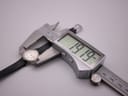 The watch is being measured by digital callipers, which show a reading of '19.19 mm' on its display, highlighting the watch's small size.