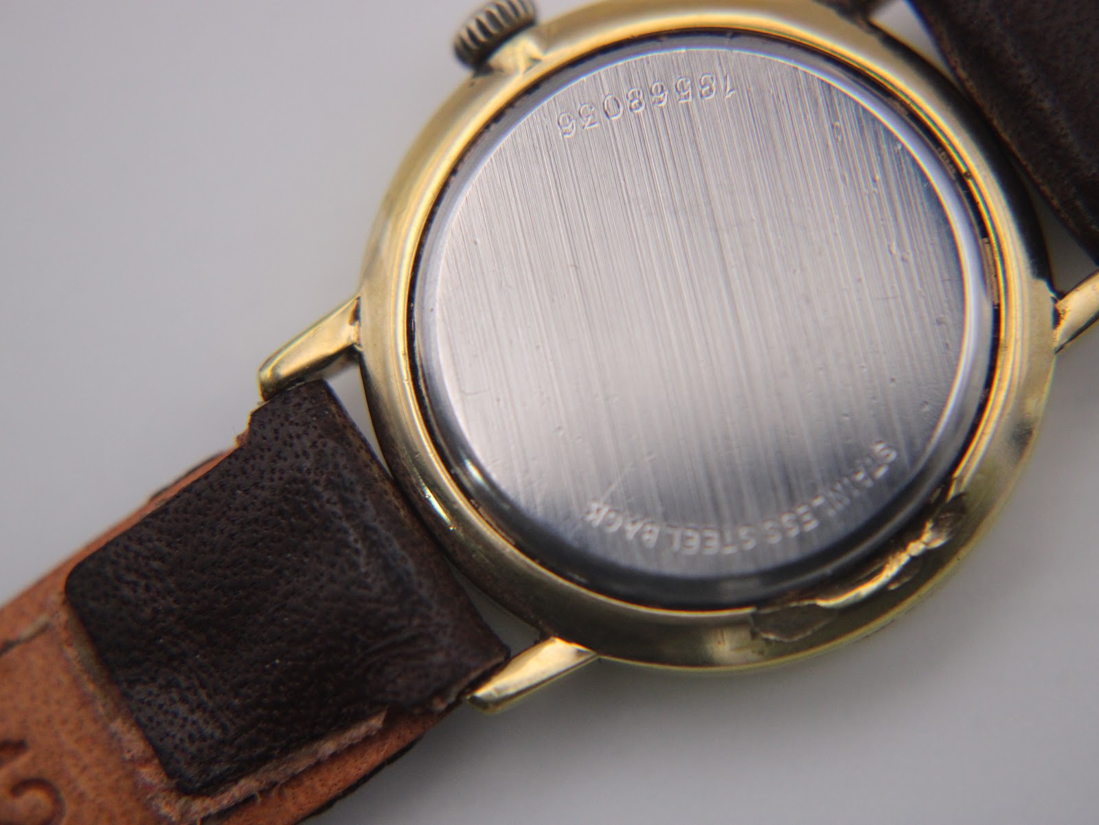 Close-up of the stainless steel case back with serial number 18568036 engraved, and 'STAINLESS STEEL BACK' text.
