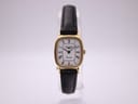 Front view of the Longines 6486 ladies watch with gold tonneau case and white Roman dial on a stand.