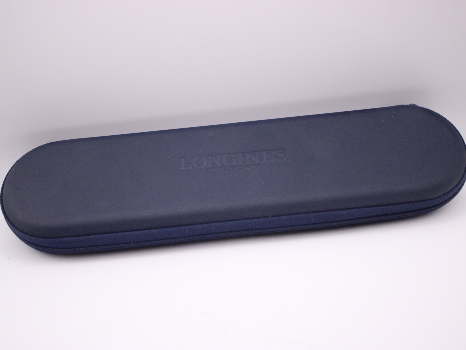 Top view of the closed original navy blue Longines travel case with 'LONGINES' embossed.