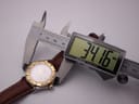 View of the watch being measured by a digital caliper, displaying a case size of 34.16mm.
