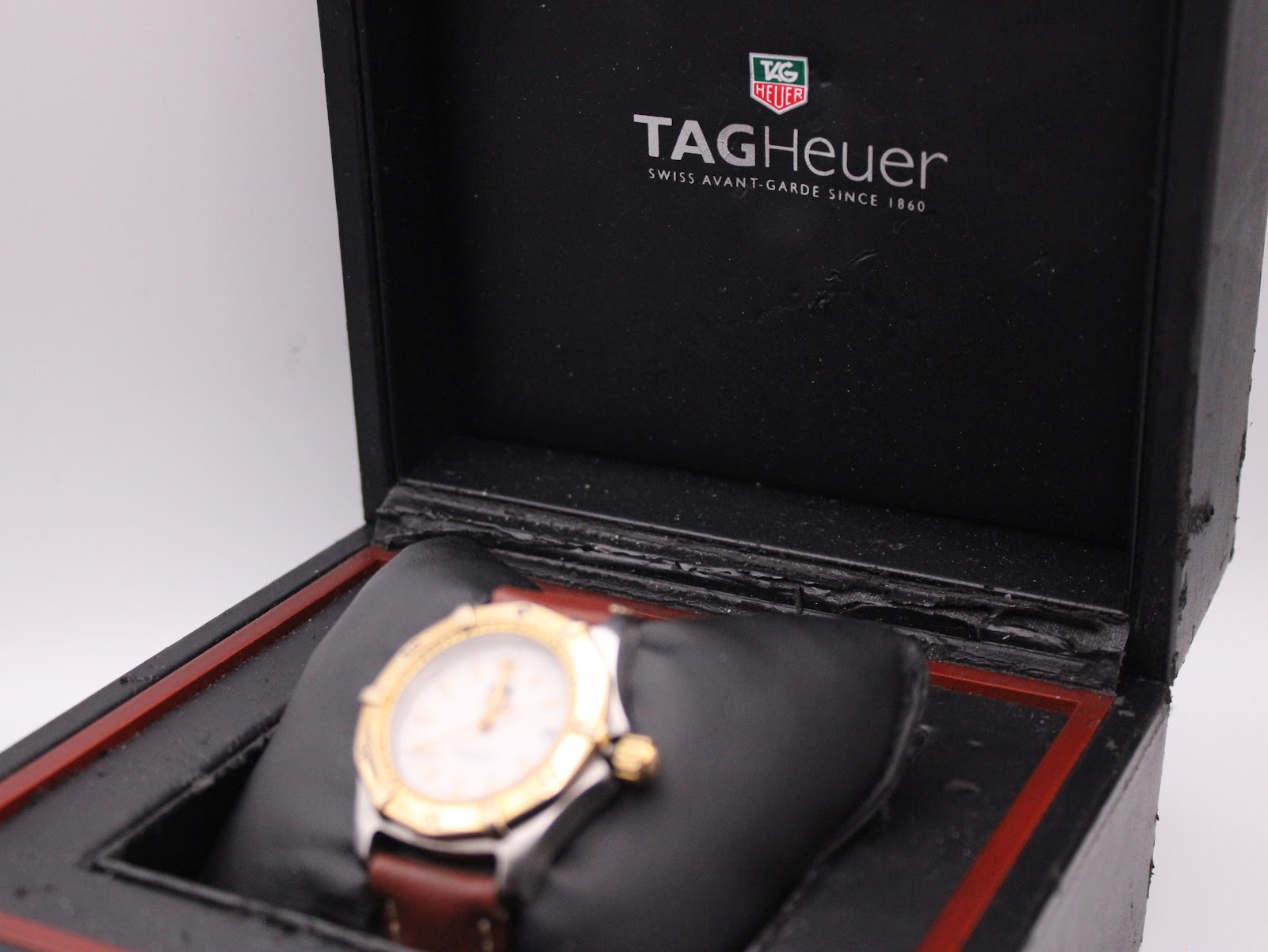 Close-up of the watch within its box, with the TAG Heuer logo visible on the inner lid.