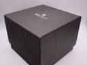 The outer dark grey cardboard box for the TAG Heuer watch, with branding.