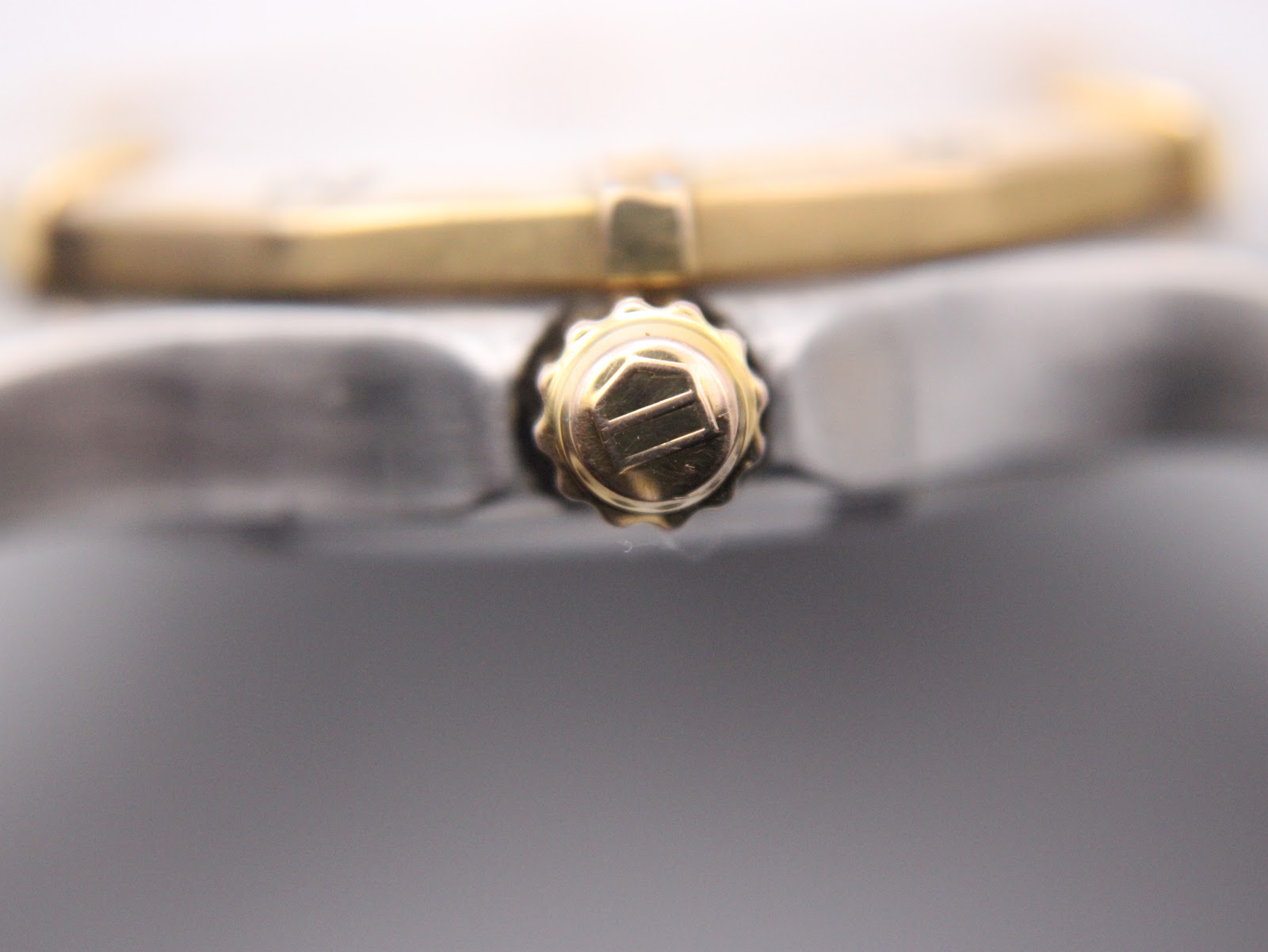 Close-up of the gold-plated crown, featuring the iconic engraved TAG Heuer logo.