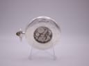 Back view of The Heritage Collection pocket watch on a stand, showing the exhibition case back revealing the manual wind movement and engraved detailing.