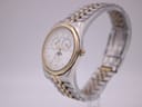 Angled side view of the Tissot PR 100 watch, highlighting the gold-plated bezel and two-tone jubilee bracelet.