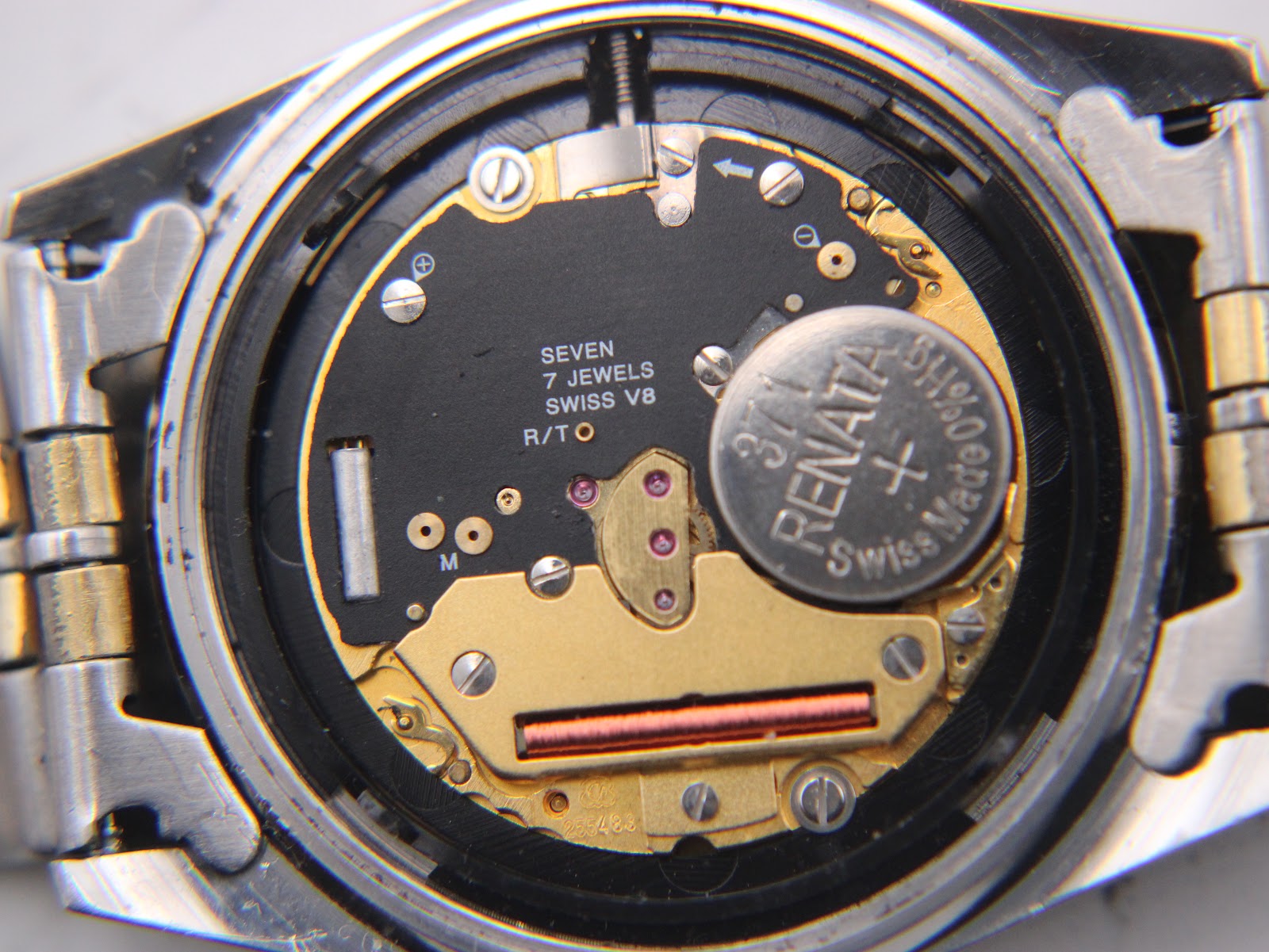 Open case back revealing the Swiss quartz movement with "SEVEN 7 JEWELS SWISS V8" inscription and Renata battery.