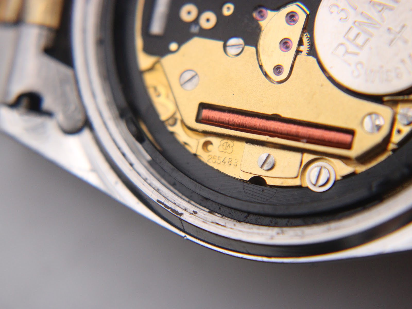 Extreme close-up of the Tissot quartz movement, showing the serial number 255483.