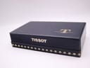 Top-down view of the closed original Tissot blue watch box with the Tissot logo embossed.