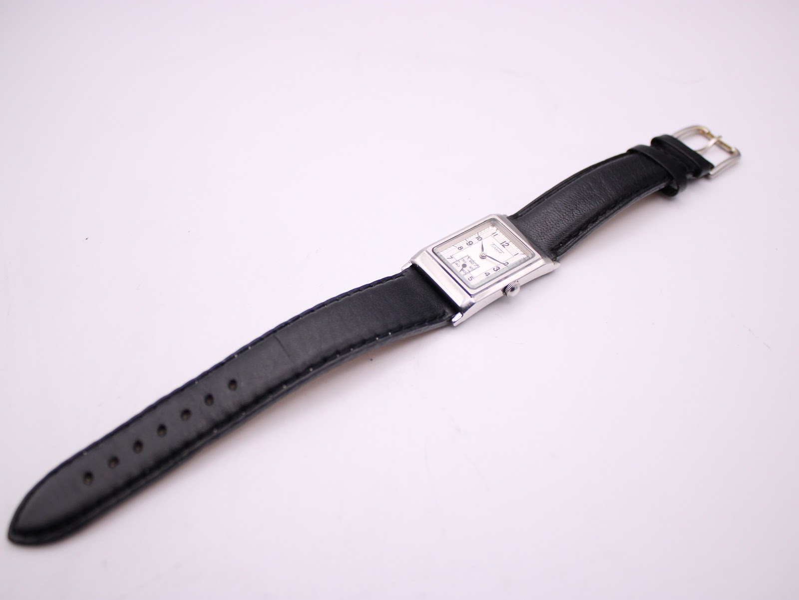 Overhead view of the Tissot Z173K watch laid flat, displaying the full length of the black leather strap.