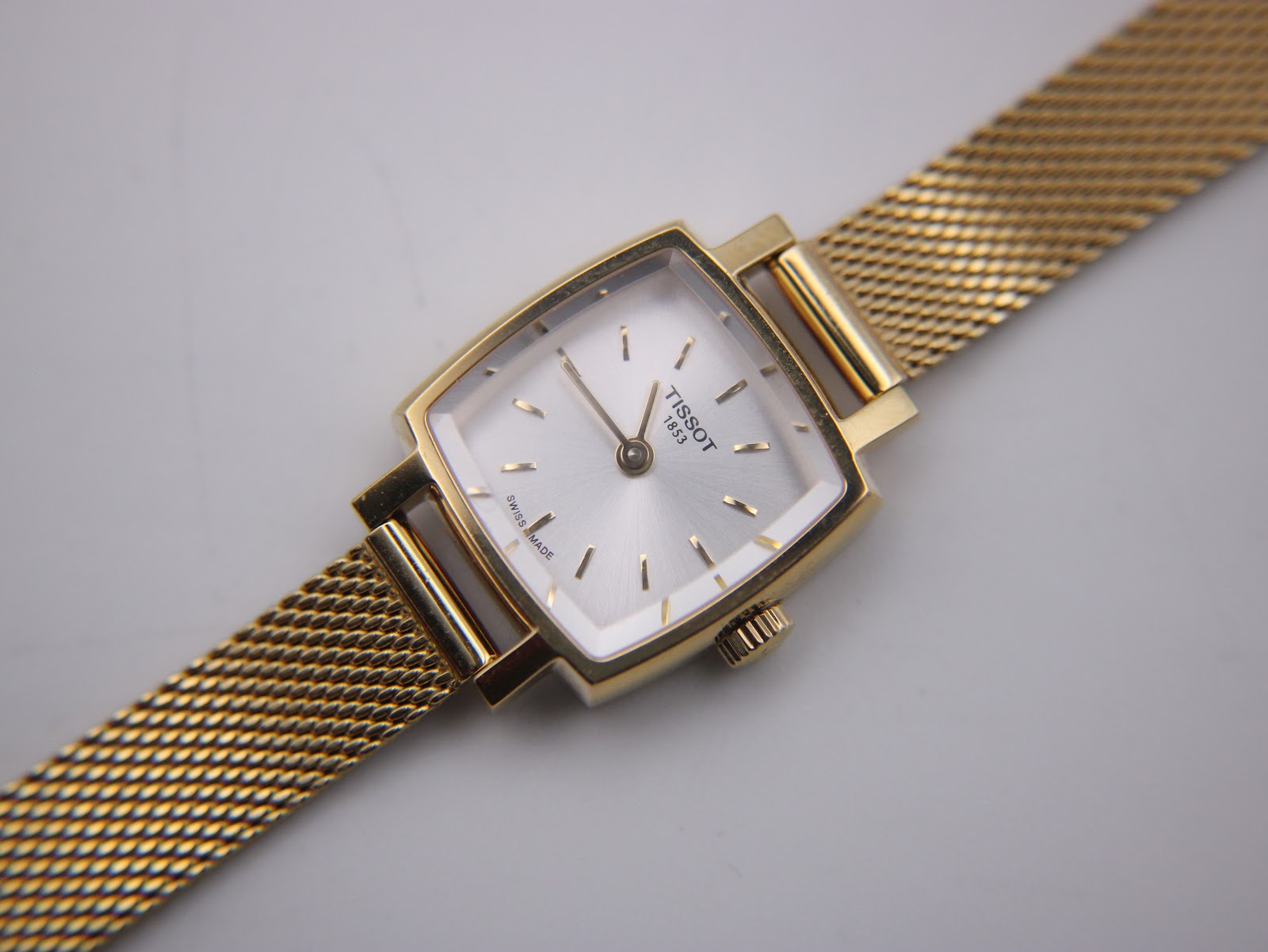 Close-up front view of the Tissot T058109 A watch dial, showing the silver sunburst finish and gold-tone baton indices.