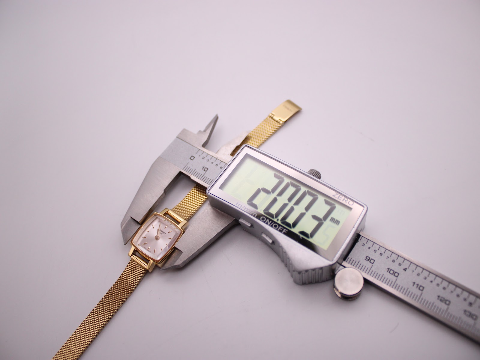 Digital caliper measuring the case diameter of the Tissot watch, displaying 20.03mm.