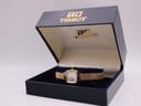 The Tissot watch displayed neatly within its original blue velour and gold branded presentation box.