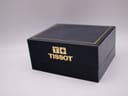 Exterior view of the closed Tissot branded black and gold presentation box.