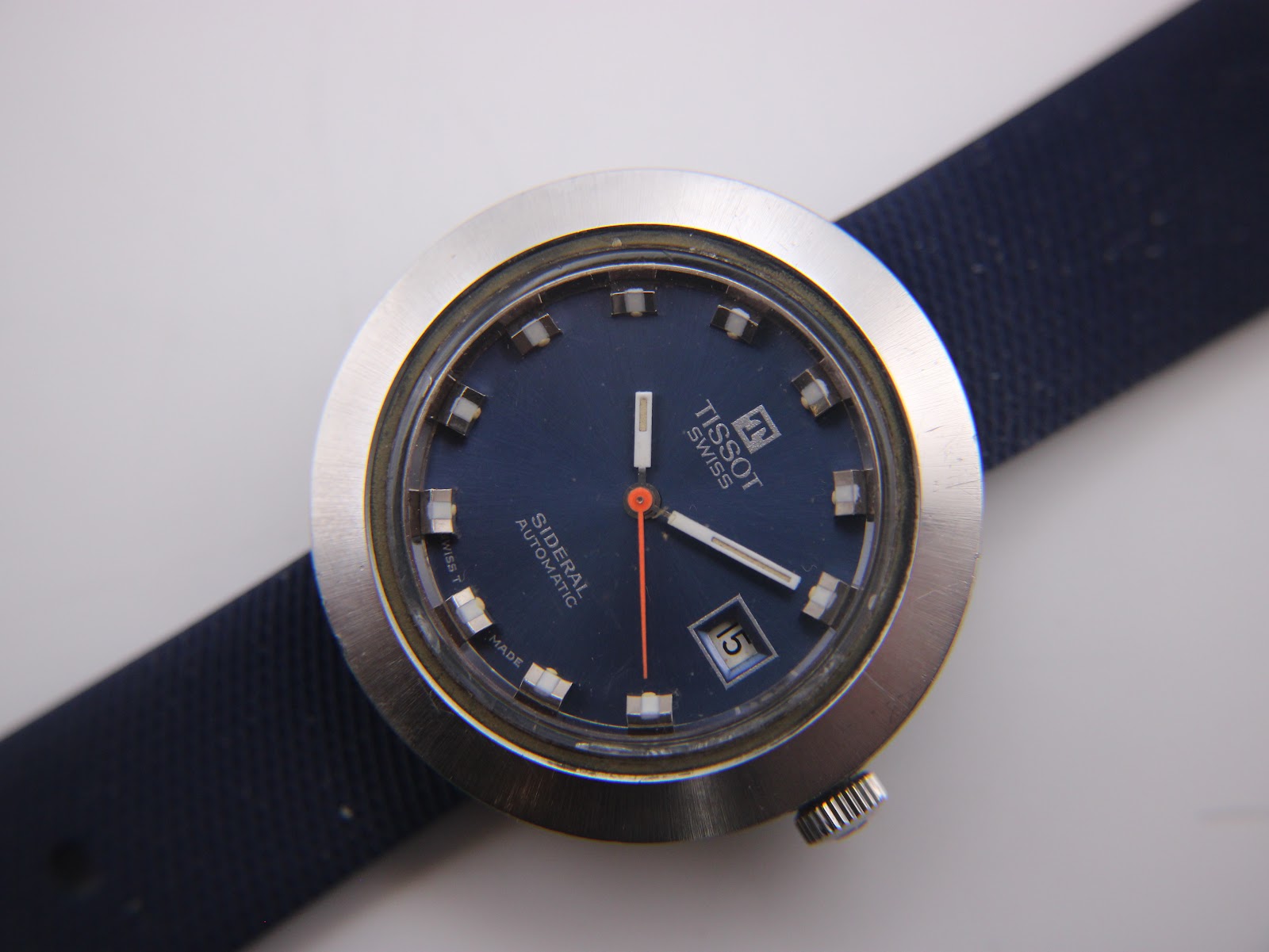 Close-up of the Tissot Sideral's blue dial, showing the Tissot logo, Sideral Automatic text, date window, and baton indices.