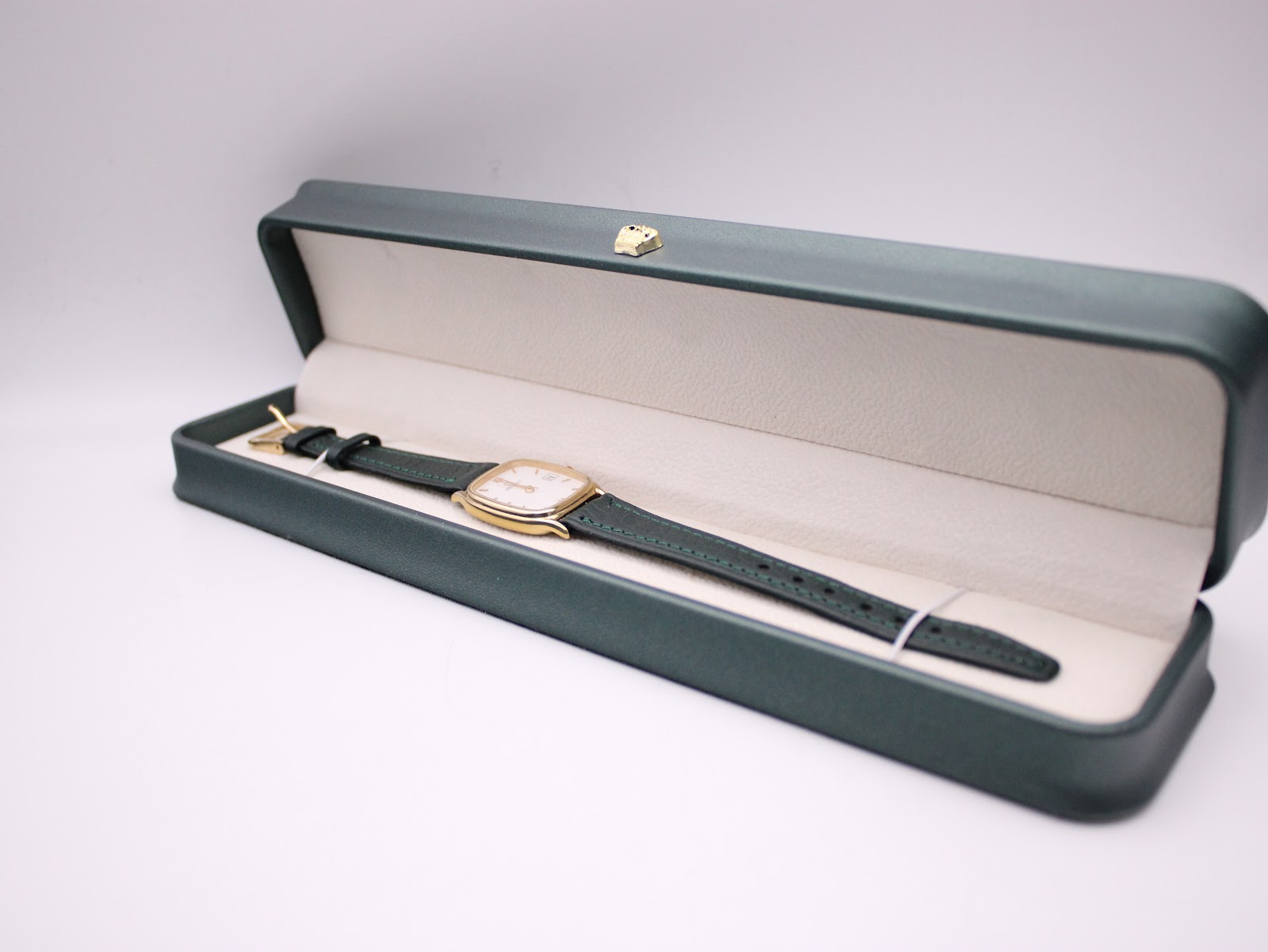 The Zenith watch nestled inside its original dark green presentation box with a cream interior.