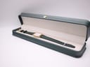 The Zenith watch nestled inside its original dark green presentation box with a cream interior.