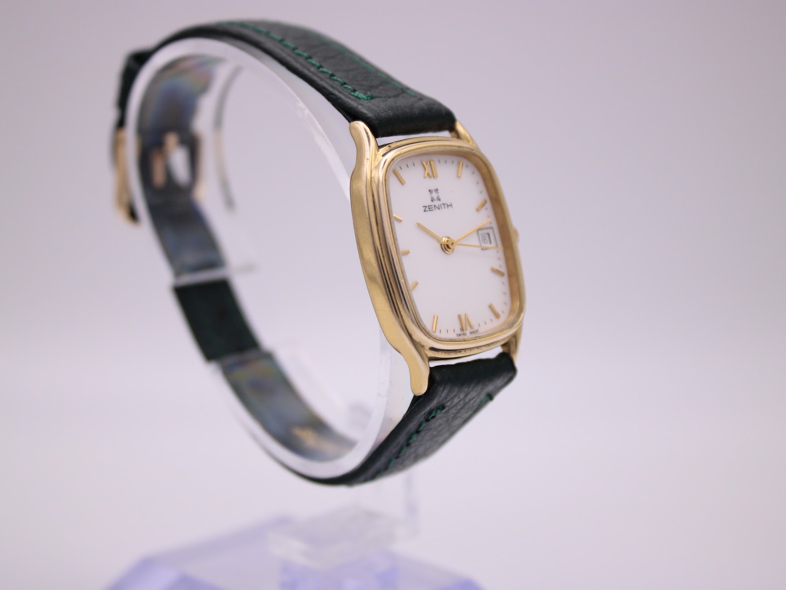 Three-quarter view of the Zenith watch, highlighting the case shape and dark green leather strap.