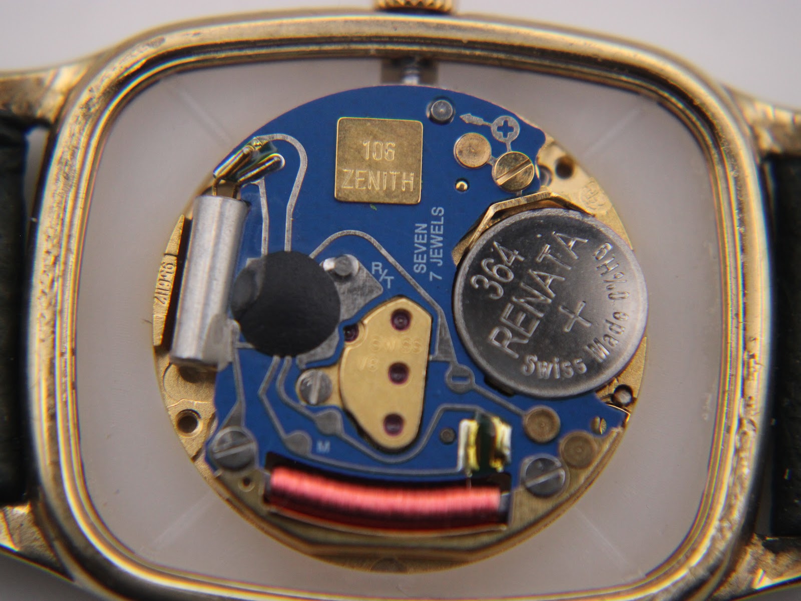 Detailed view of the Zenith Swiss quartz movement inside the watch case, showing "ZENITH" and a Renata battery.