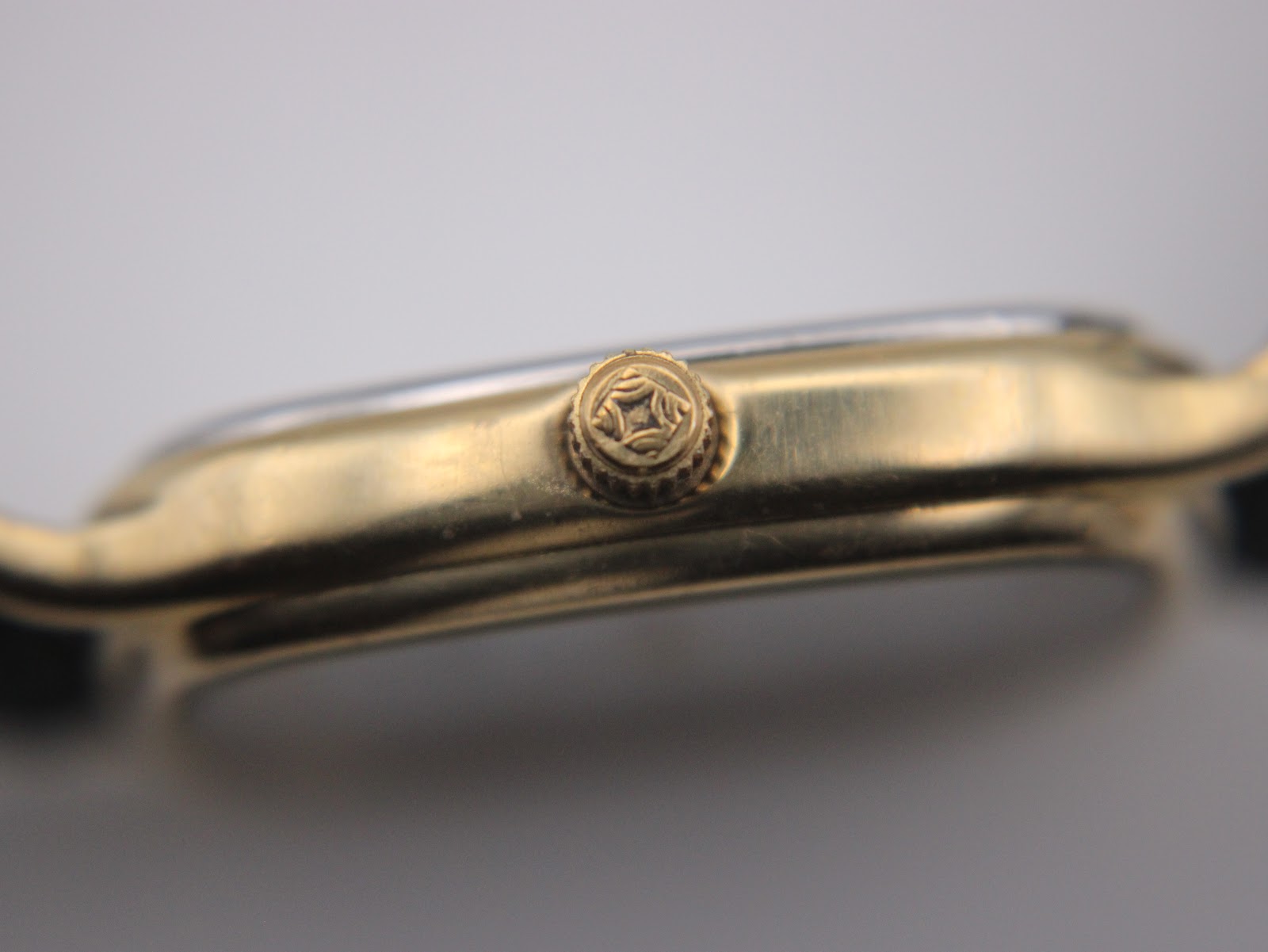 Close-up side view of the watch crown, showing its fluted design.