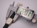 Digital caliper measuring the watch case width, displaying 22.01 mm.