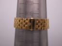 Gold-tone Michele bracelet wrapped around a wrist sizing gauge, showing a wrist circumference of approximately 14.5 cm.
