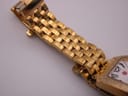 Close-up view of the gold-tone Michele bracelet links and part of the case on a white background.