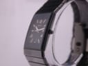 Angled view of the Rado Diastar watch on a display stand, showcasing the rectangular case and the seamless black ceramic bracelet.