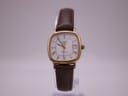 Side view of Longines Presence watch highlighting the watch profile and crown, brown strap on clear stand.