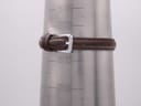 A dark brown leather watch strap with a silver-tone buckle is fastened around a metal wrist sizing cone, displaying various size measurements.