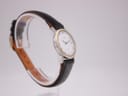 Alternative angled side view of the Omega De Ville watch on a stand, highlighting the two-tone case.