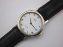 Close-up, top-down view of the Omega De Ville's white dial with black Roman numerals and date window at 3 o'clock.