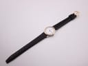 Full overhead view of the Omega De Ville watch with its black leather strap fully extended on a white background.