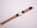 Full rear view of the Omega De Ville watch, showing the light brown underside of the leather strap and gold-toned buckle.