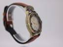 Opposite angled side view of the Camel Trophy watch on a clear stand, showing the case profile and strap attachment.