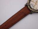 Close-up of the lower brown leather strap section, showing more embossed branding and the stitching detail.
