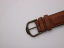 Detailed shot of the bronze-tone pin buckle, clearly engraved with the 'CAMEL' brand name.
