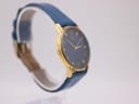 Angled view of the Citizen watch from the left, showing the gold-tone case and blue leather strap.