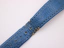 Close-up of the worn blue leather strap, showing wear, cracking, and peeling near the buckle holes, with '18' indicating lug width.