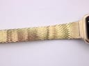 Another detailed close-up of the gold-tone mesh bracelet, showing its intricate woven pattern near the watch case.