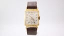 Front angled view of the Gruen Curvex watch, showing cream dial with gold Arabic numerals and sub-seconds.