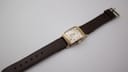 Straight side view of the watch, showing the crown and the curved profile.