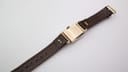 Side profile view of the Gruen Curvex, highlighting the curved case and crystal with brown leather strap.