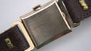 Side view of the watch crown and curved case, showing the profile of the crystal and twisted lugs.